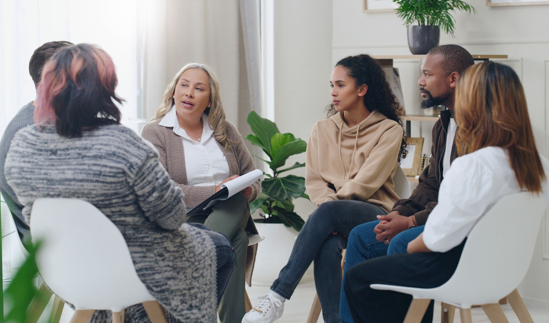 Asesoramiento, discusión grupal y psicológica con un grupo de personas de diversidad en terapia para la depresión, el estrés y la ansiedad. Hombres y mujeres sanando durante reunión de psicólogos hablando sobre salud mental