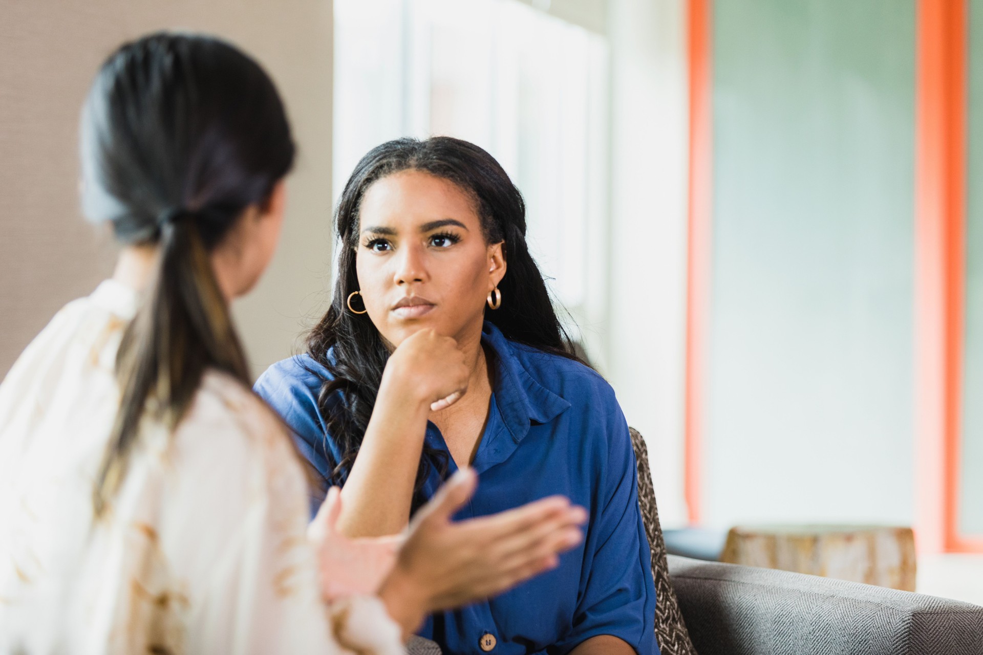 Unrecognizable female patient gestures as female therapist listens attentively